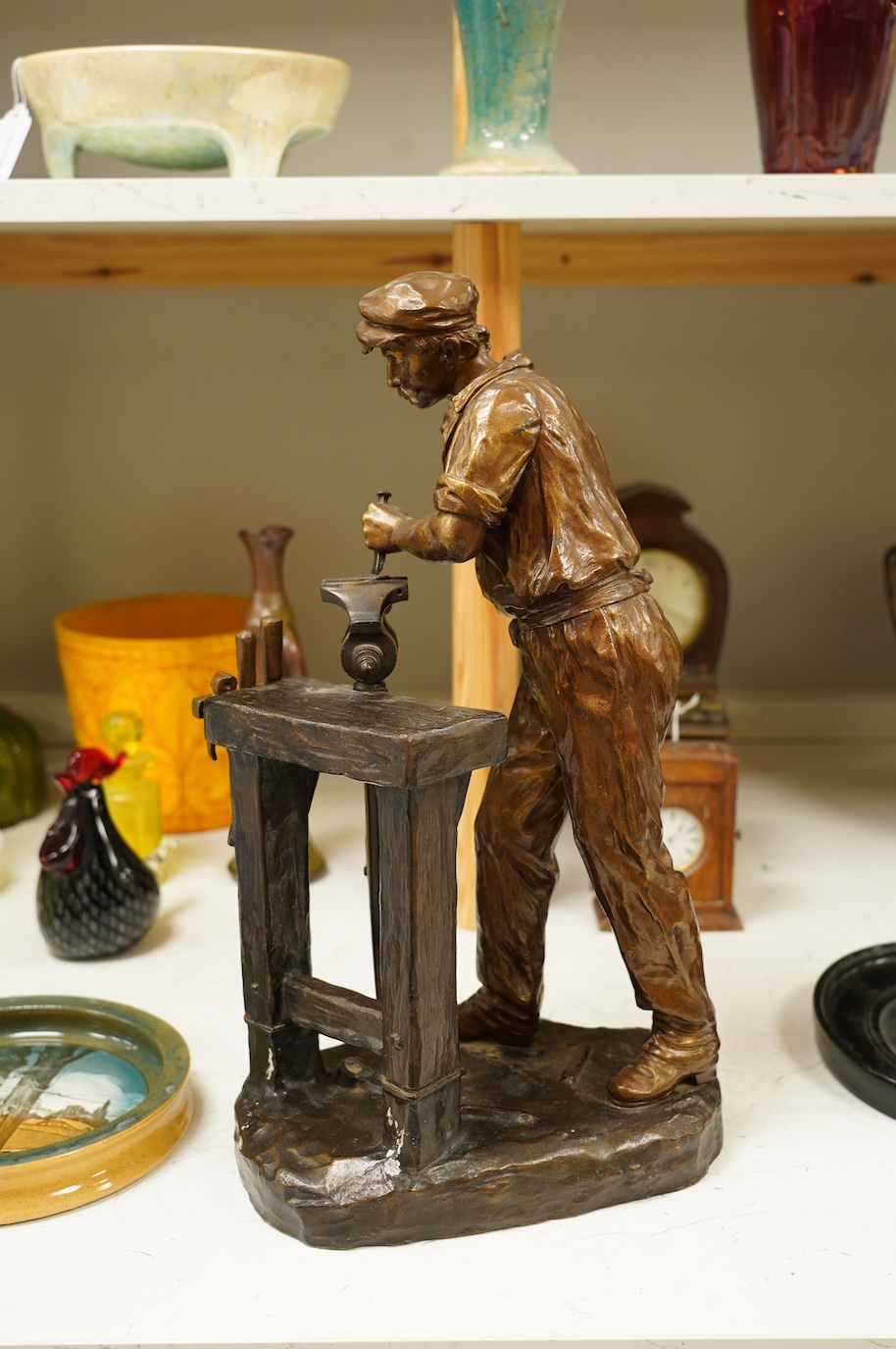 A large bronze of a blacksmith and work bench, signed Carlier, 42cm high. Condition - good